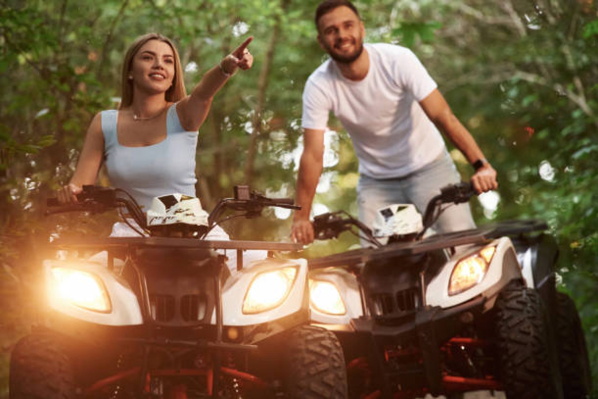 Positive facial expression. Man and woman are on ATV outdoors.